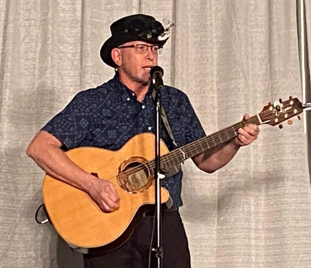Stace performs onstage during the intermission of the Masquerade for MileHiCon.